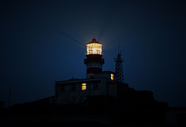 A lighthouse guiding light at night